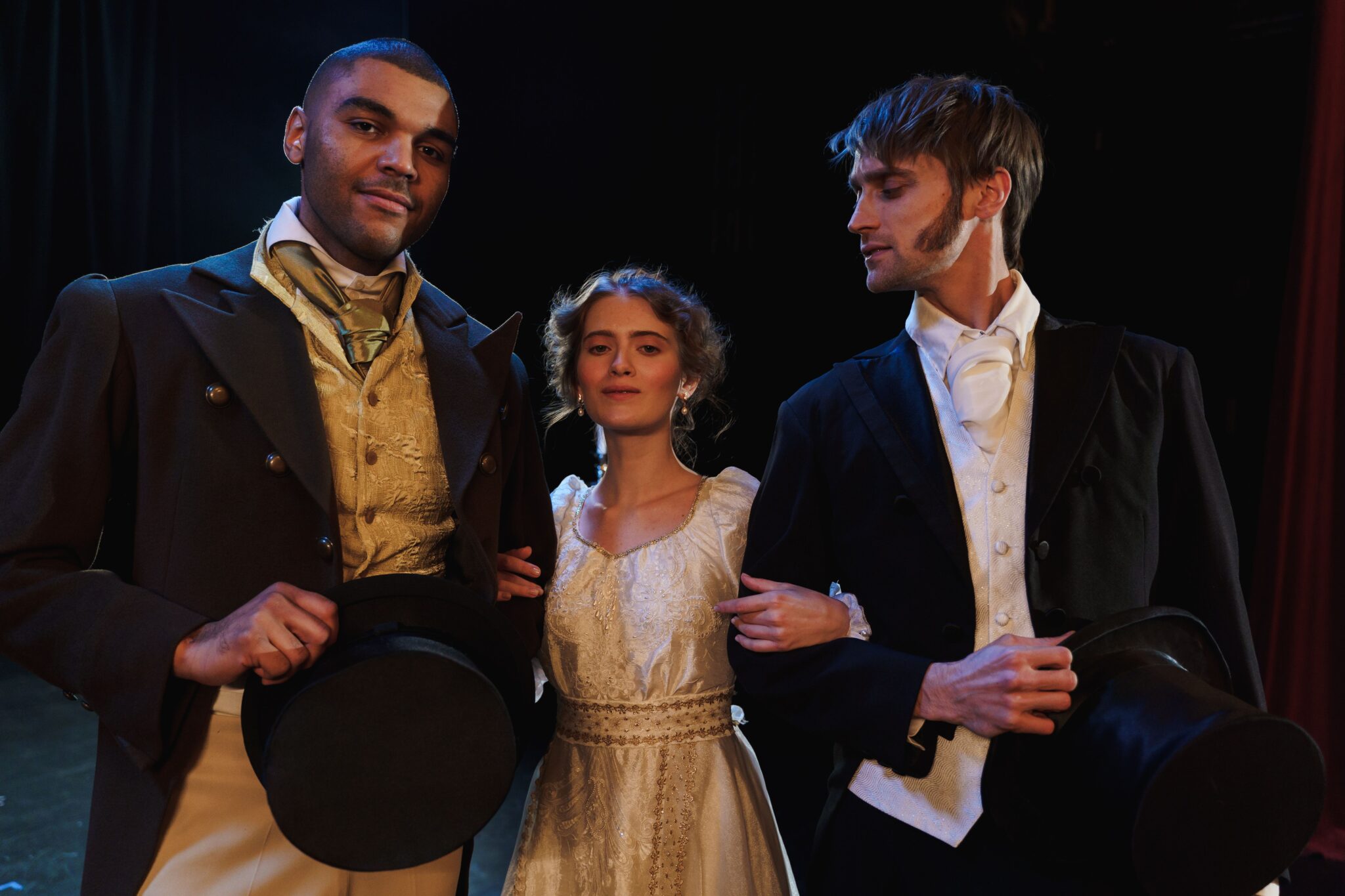 Fotografia il·lustrativa de tres intèrprets amb vestuari d'època en un escenari teatral; no correspon a la producció de La Bohème al Liceu.