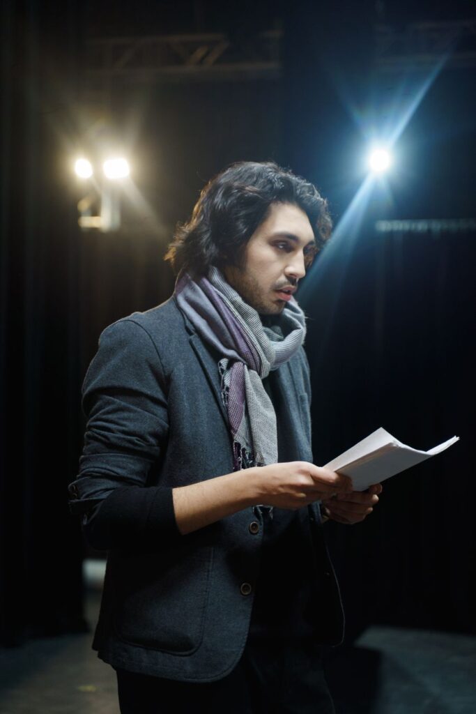 Actor leyendo su texto bajo un foco